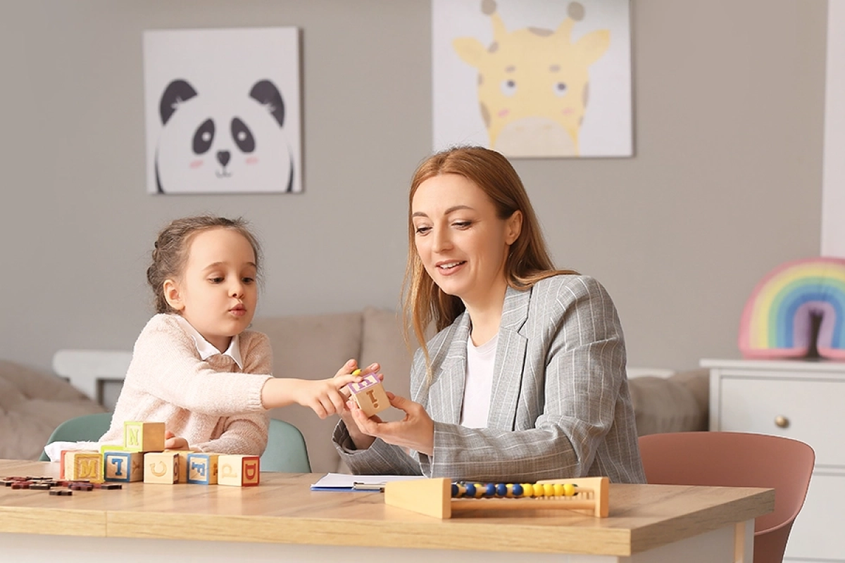 Éducatrice spécialisée accompagnant un enfant avec des activités éducatives - séance d'apprentissage individualisée et bienveillante